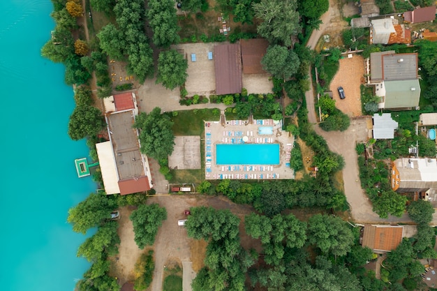 Luxury real estate on the shore of a azure pond top view drone shot