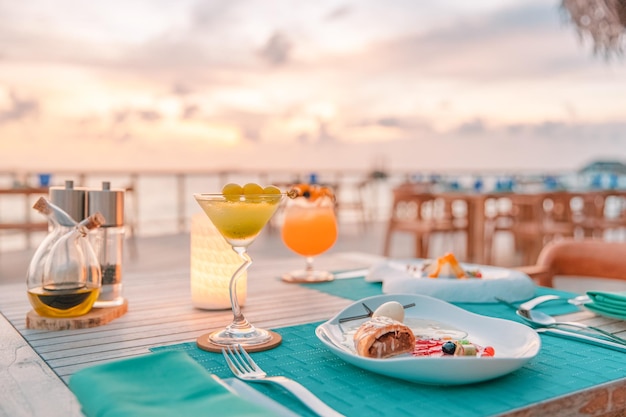 Luxury sunset dinner gourmet food on wooden table, beautiful tropical resort and sea view, elegant