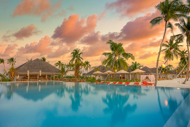 Luxury sunset over infinity pool in a summer beachfront hotel resort at tropical landscape. Tranquil