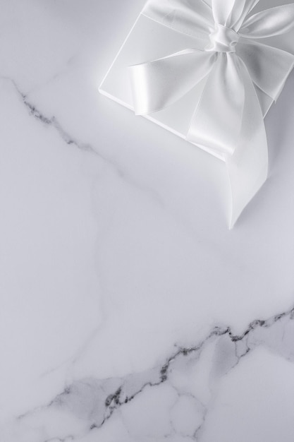 Luxury wedding gifts with silk bow and ribbons on marble background