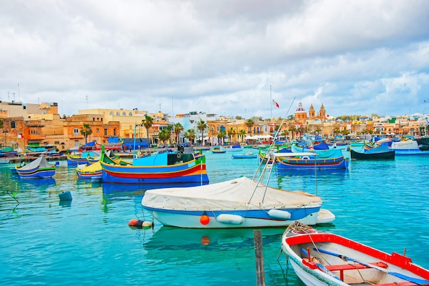 Luzzu colorful boats, Marsaxlokk harbor in the bay of the Mediterranean sea, Malta island