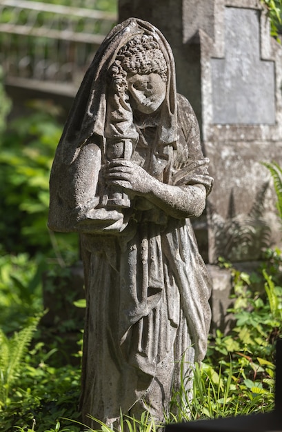 Lviv, Ukraine - May 25, 2020: Old Lychakiv Cemetery in Lviv. Old statue on grave in the Lychakivskyj cemetery