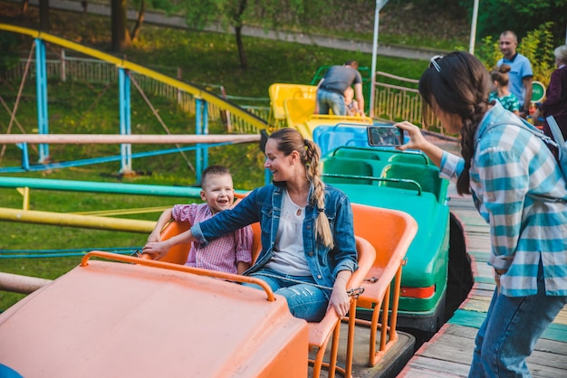 LVIV UKRAINE  September 1 2018 people riding attraction in city park having fun mother with kid