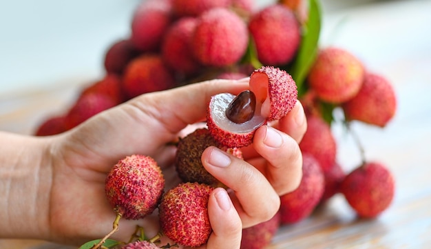 Lychees on hand fresh ripe lychee fruit tropical fruit peeled lychees slice in Thailand