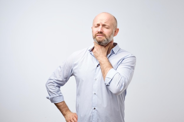 Maature european man having oain in throat because of flu