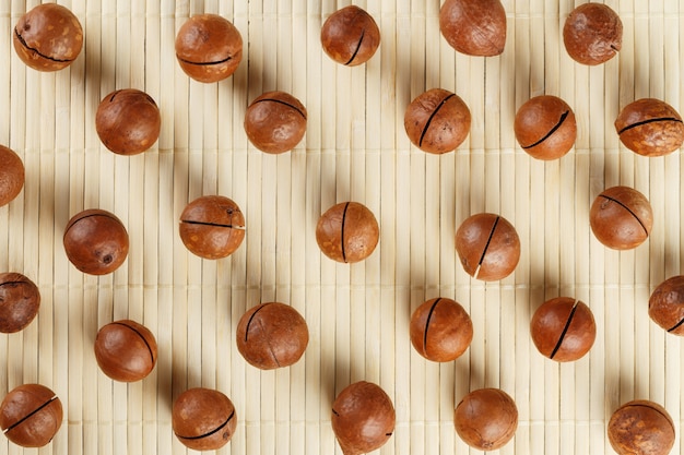 Macadamia nuts pattern on a bamboo background