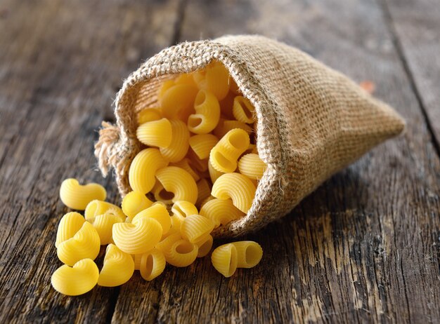 Macaroni In the sack on wood table