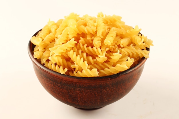 Macaroni spiral in a bowl on a white surface