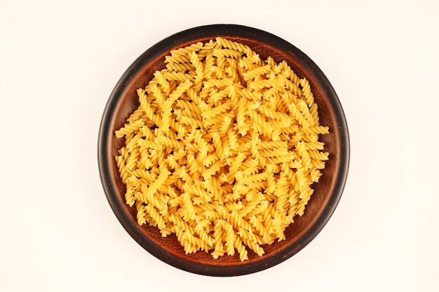 Macaroni spiral in a plate on a white surface