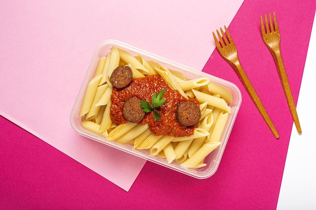 Macaroni with tomato sauce chorizo and cheese in plastic container