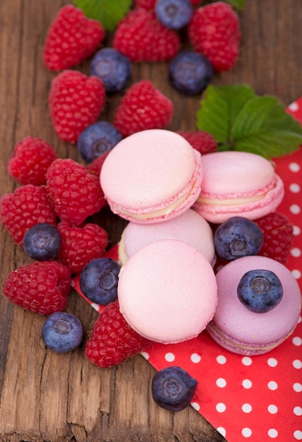 Macarons blueberries and raspberries on a wooden background