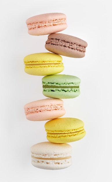 Macaroon. Colorful cake macaron with pastel tones chaotic stacked in a row on white wall. Top view of almond cookies.