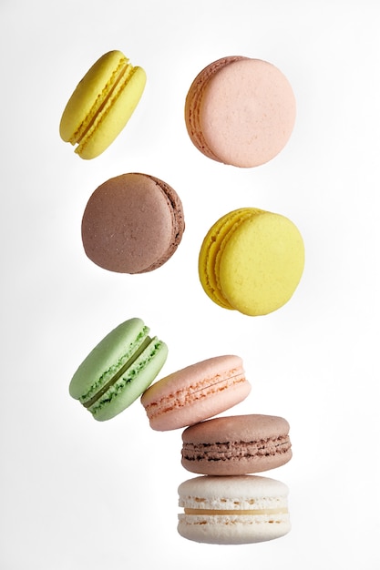 Macaroon. Colorful cake macaron with pastel tones fall at the stack macaroon on white wall. Top view of almond cookies.