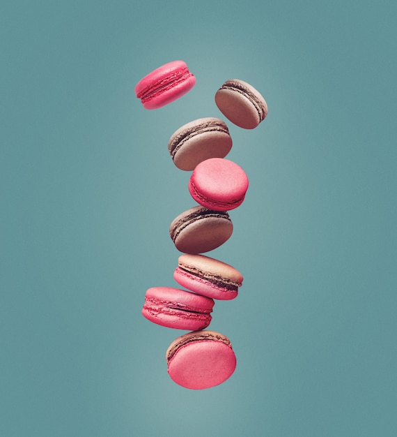 Macaroons, composition of colorful french cookies macarons in the air. Beige, brown french cookies macarons