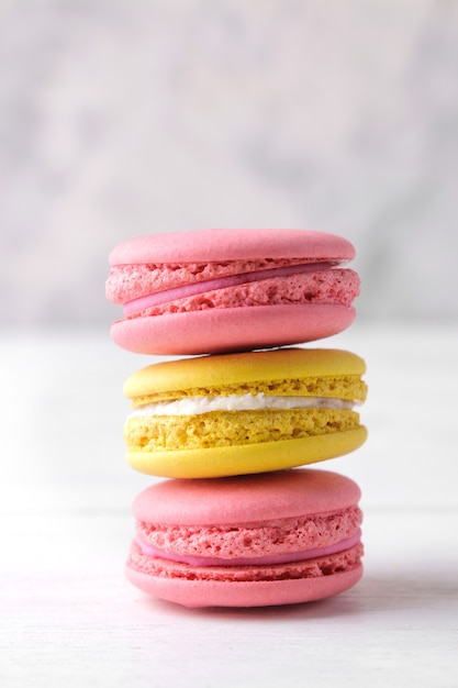 Macaroons. delicious colored french macaroni cakes on a white wooden table.