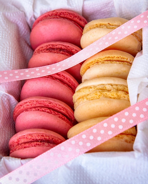 Macaroons with strawberry and vanilla filling in a gift box