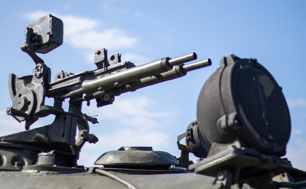 Machine gun on the turret of an armored personnel carrier Heavy weapons of war blue sky background