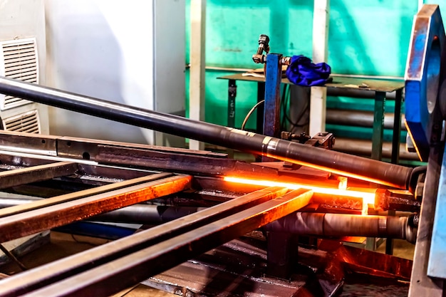 Machine for induction heating of metal A metal rod heated in an induction furnace Hot metal processing Metalworking in the industrial workshop at the factory