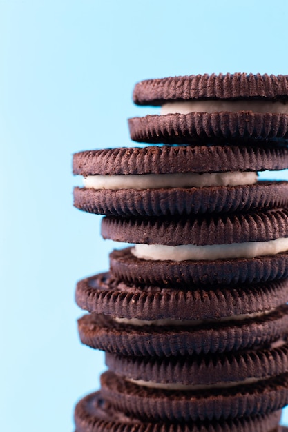 Macro chocolate cookies and white cream isolated on blue backgroundxA