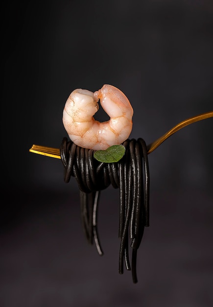 Macro food photography of black spaghetti and shrimp