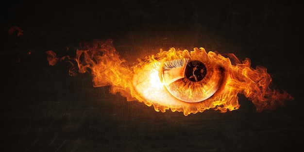 Macro image of human eye in fire. Mixed media