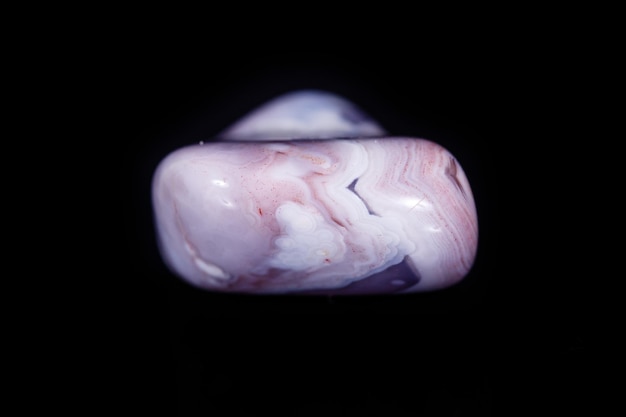 Photo macro mineral stone agate pink persian on a black background