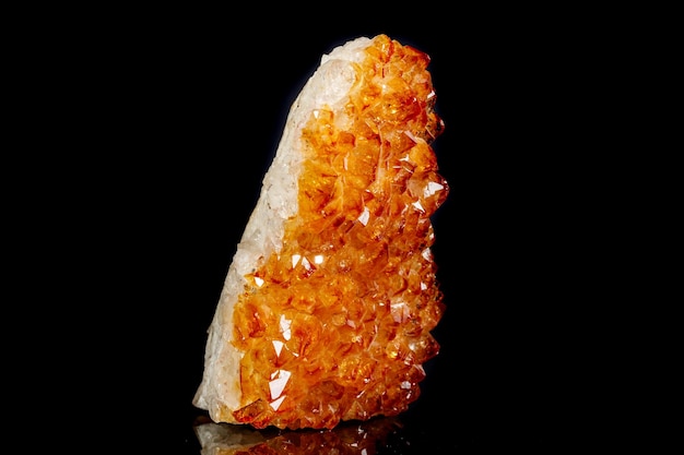 Macro mineral stone Citrine in rock in crystals on a black background