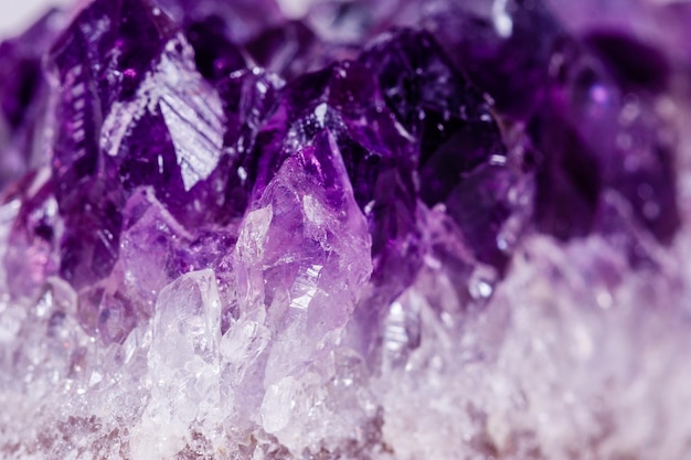 Macro mineral stone purple amethyst in crystals on a white background