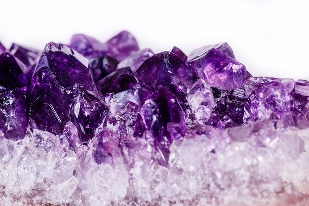 Macro mineral stone purple amethyst in crystals on a white background