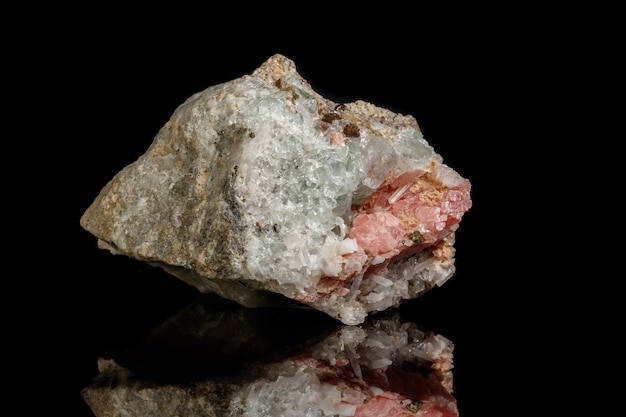 Macro of the mineral stone Rhodochrosite with fluorite on a black background