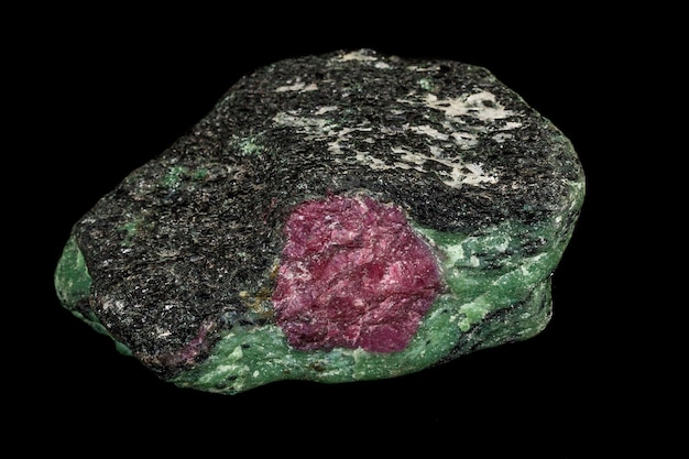 Macro of mineral stone ruby in rock on black background