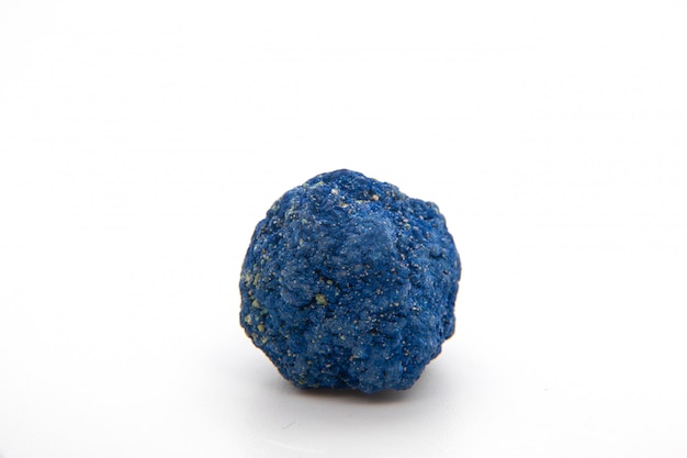 Macro of natural mineral rock specimen of raw azurite stone isolated on a white background. Ore azurite semiprecious geological crystal.