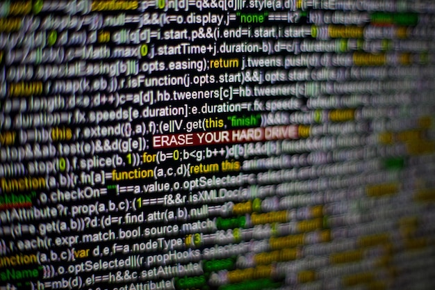 Macro photo of computer screen with program source code and highlighted erase your hard drive