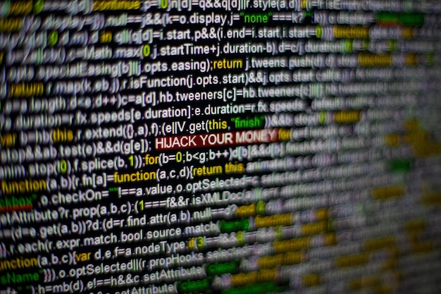 Macro photo of computer screen with program source code and highlighted hijack your money