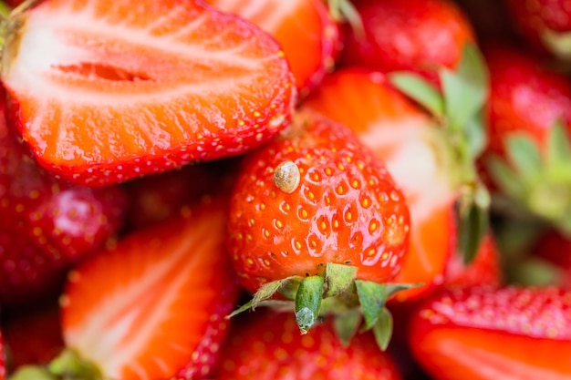 Macro photo of little snail on top of red appetizing strawberry