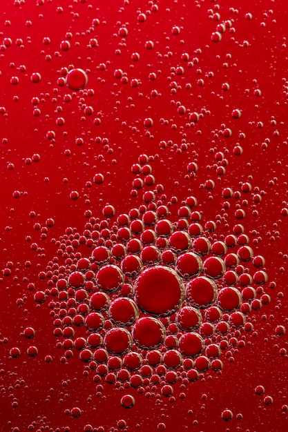 Macro photo. Oil bubbles on a water surface. Red background. Red color in water and oil.