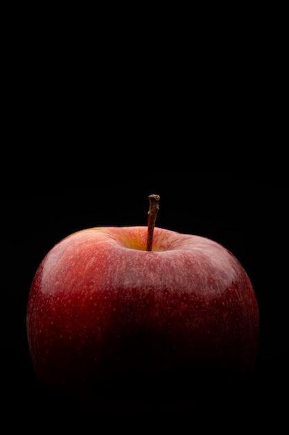 Macro photography of a red apple on a black background Vertical image with copy space