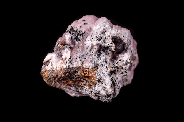 Macro pink Smithsonite mineral stone on microcline on black background