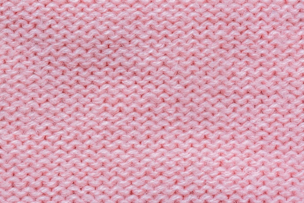 macro pink yarn,A background of hand-knitted knitted fabric with an English elastic pattern of thi