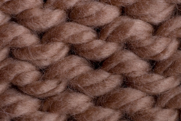 Macro shot of brown woolen knitted fabric texture.