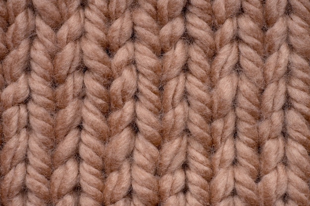 Macro shot of brown woolen knitted fabric texture.