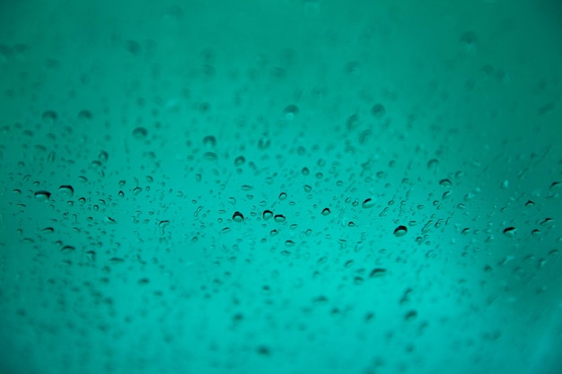 Macro shot of clear water droplets on brown surface