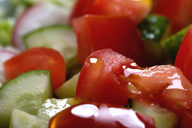 Macro shot of delicious juicy tomato and cucumber salad with herbs and onions