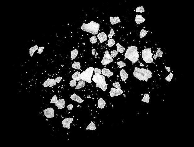 Macro shot of falling and flying salt crystals isolated on black