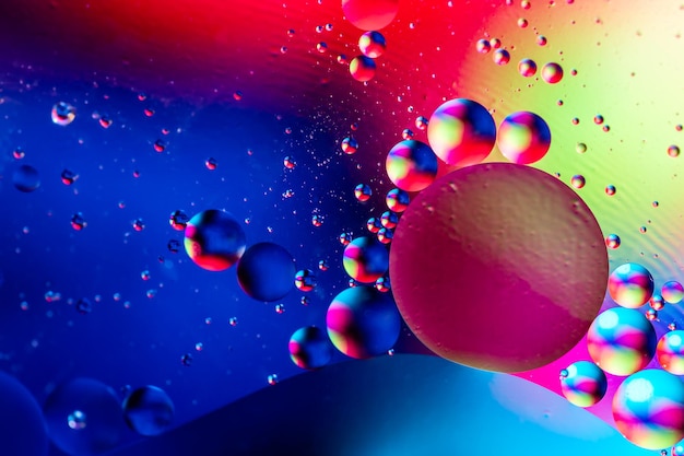 Macro shot of oil bubbles with water on colorful background. Space and universe planets styled abstract image.