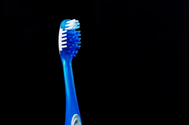 Macro shot of a toothbrush against a black background with copy space