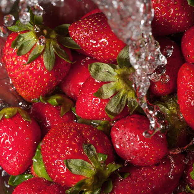 Macro shot on water falling on a group of strawberries