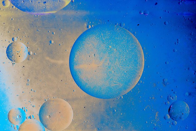 Macro shot of water oil emulsion over colored background