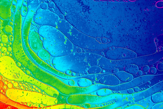 Macro shot of water oil emulsion over colored background