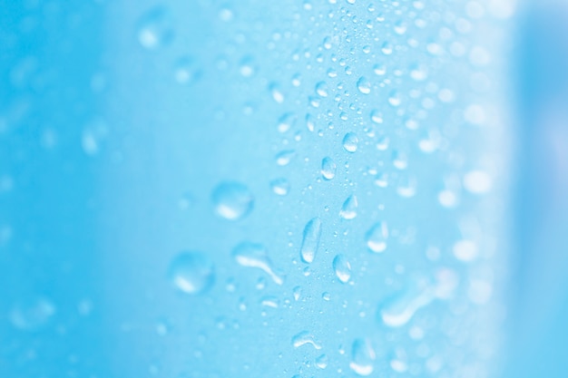 Macro of water drops on blue surface backdrop